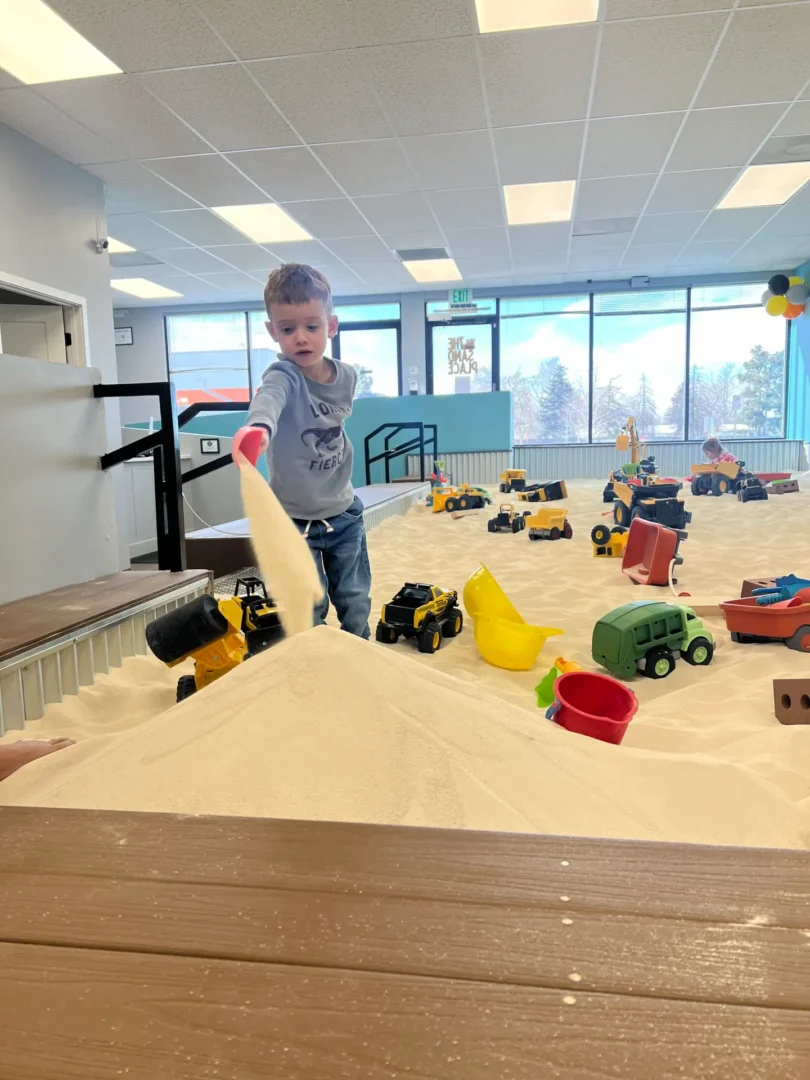 Children playing in sand at indoor play area near Denver Colorado