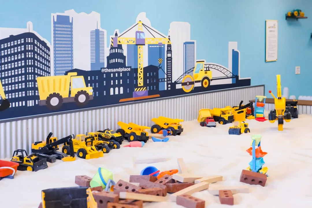 Kids digging and laughing in indoor sand area at Aurora Colorado play place