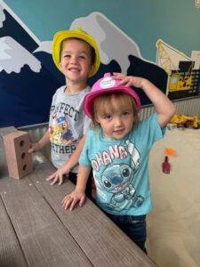 Kids wearing construction hats playing in indoor sandbox at The Sand Place indoor playground Aurora"