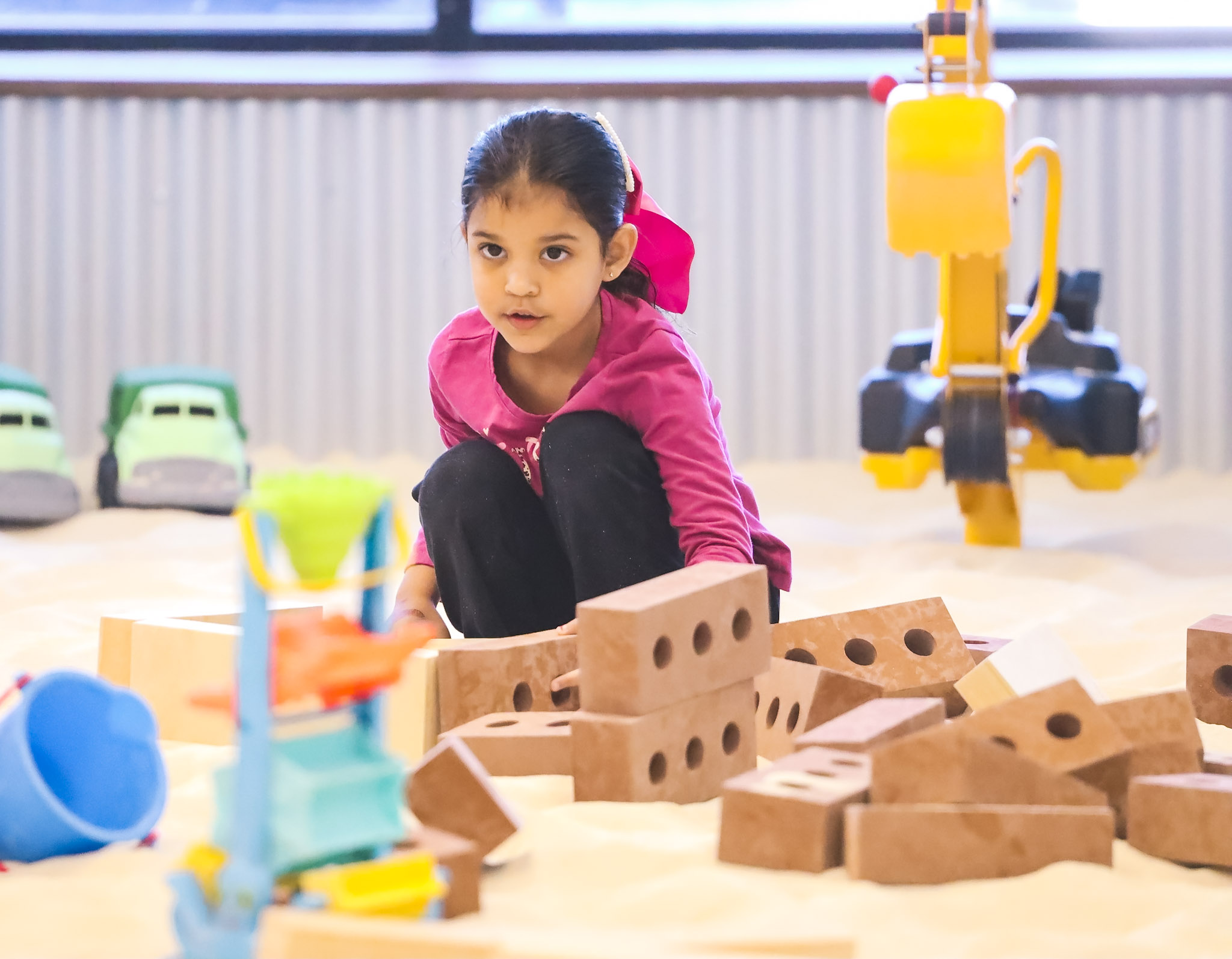 Toddlers playing with sand toys at indoor playground in Aurora Colorado
