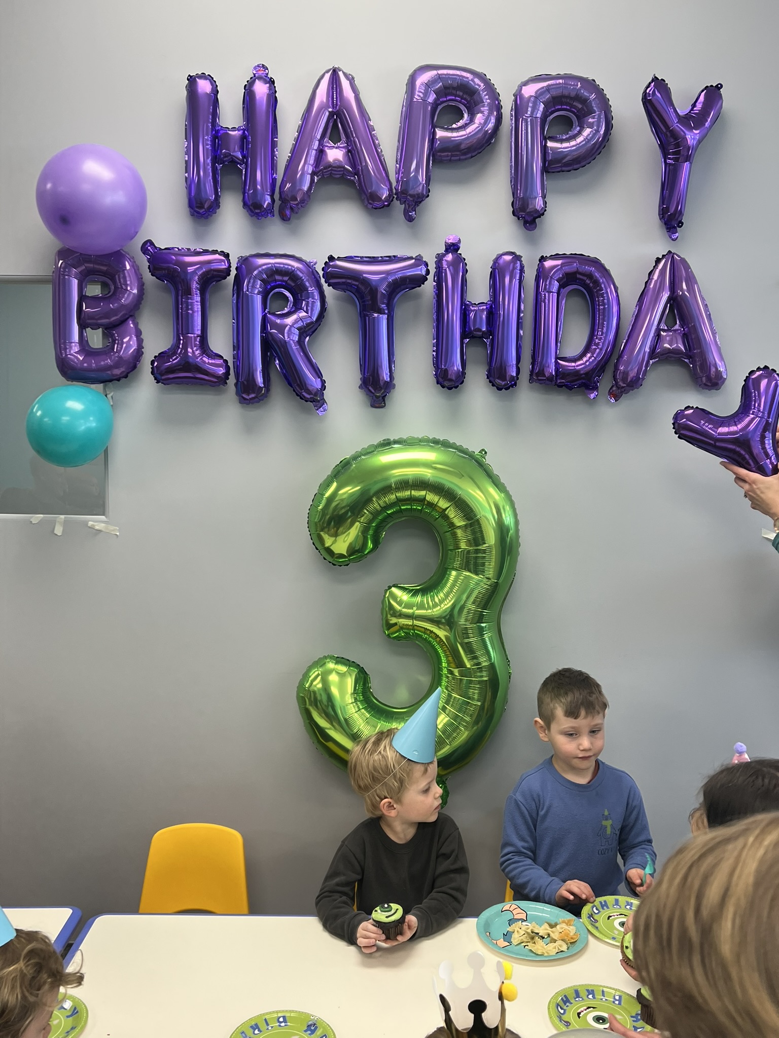 Children scooping sand with buckets at indoor sandbox near Denver
