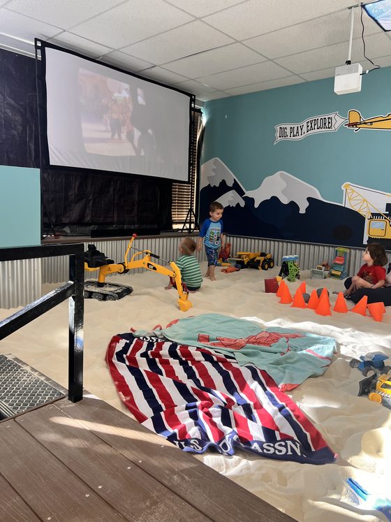 Children playing with construction toys in the sand during Movie Night at The Sand Place in Aurora